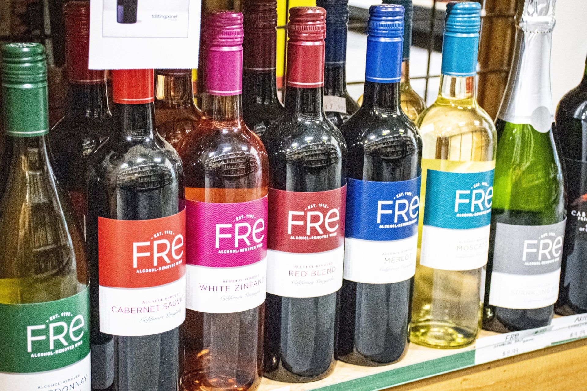 Bottles of Fre alcohol-removed wine with colorful labels, on a store shelf.