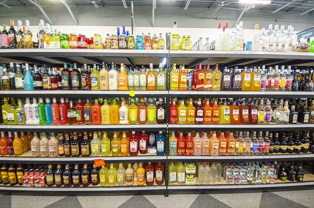 Shelves stocked with a variety of liquor bottles in a store, showcasing a diverse selection of alcoholic beverages.