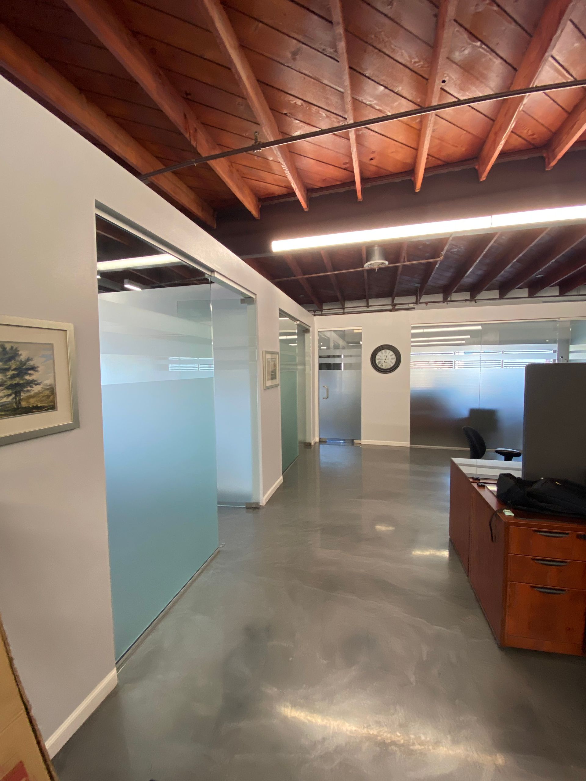 A white jeep grand cherokee is parked in front of a muffler shop.