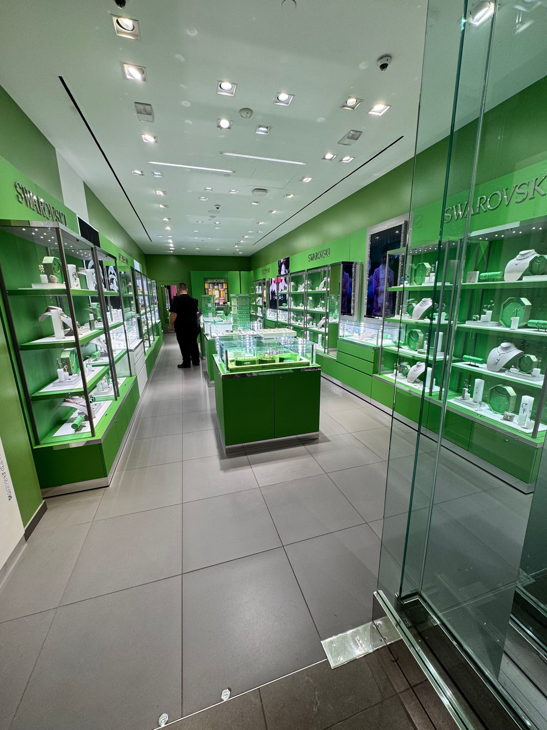 A white car with the hood up is sitting in a garage.