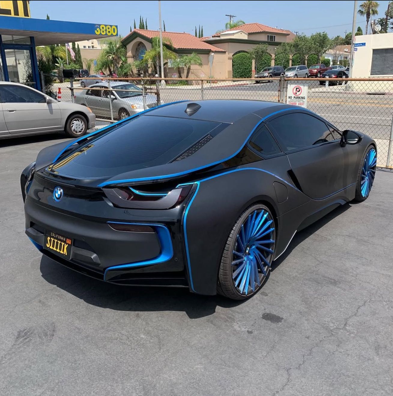A white jeep grand cherokee is parked in front of a muffler shop.