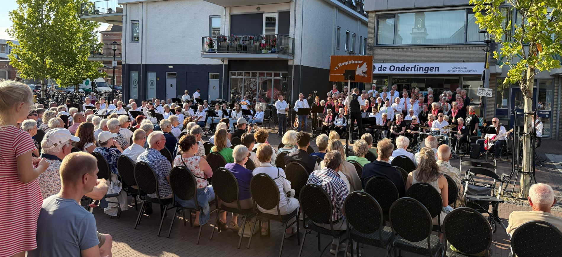 Regiokoor en muziekvereniging Lekkerkerk treden op op het Raadhuisplein tijdens zomeravondconcert