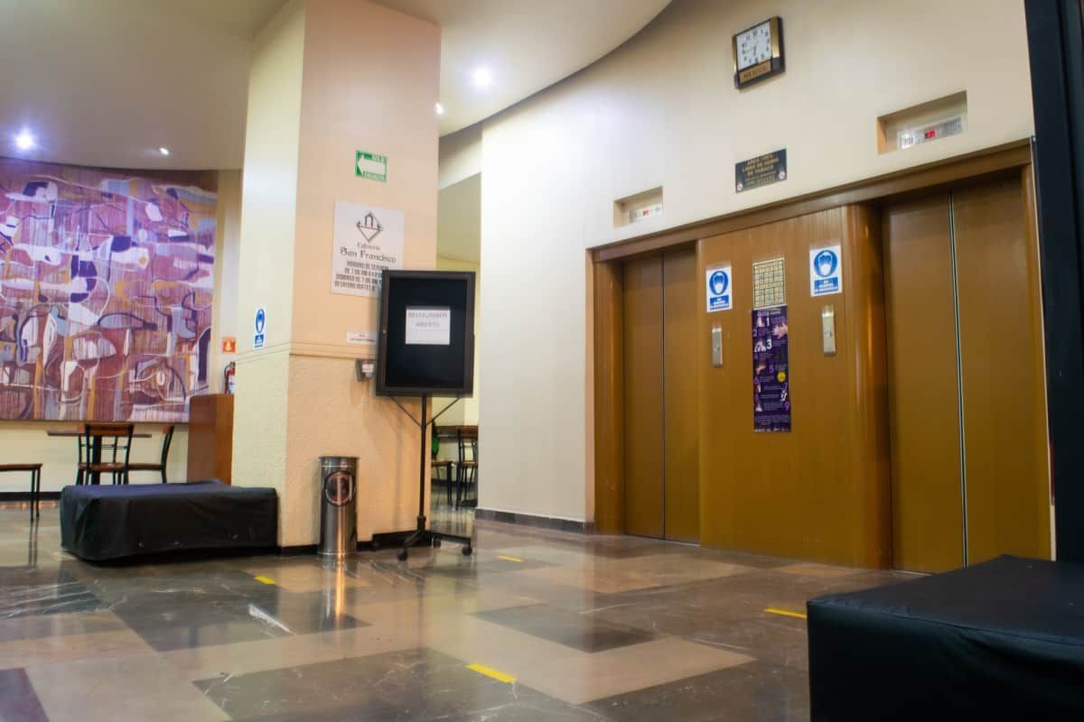 Hay dos ascensores en el vestíbulo de un edificio.