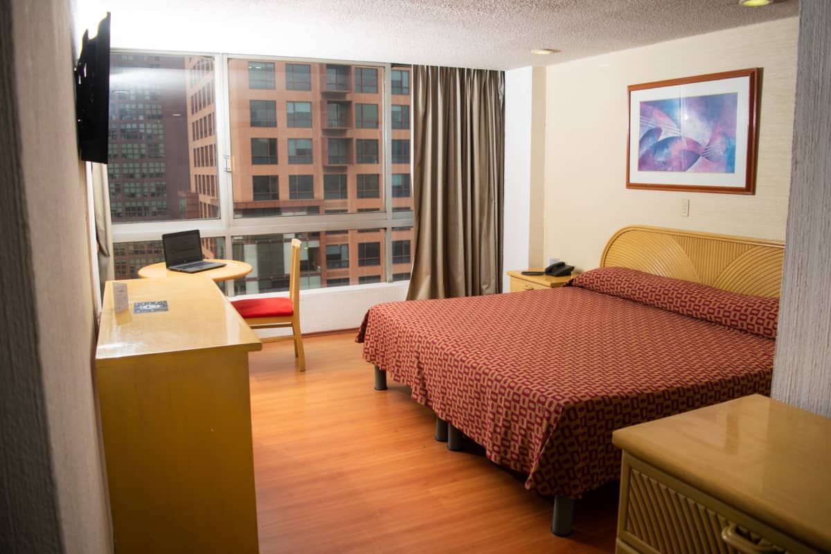 Una habitación de hotel con dos camas, un escritorio y una televisión.