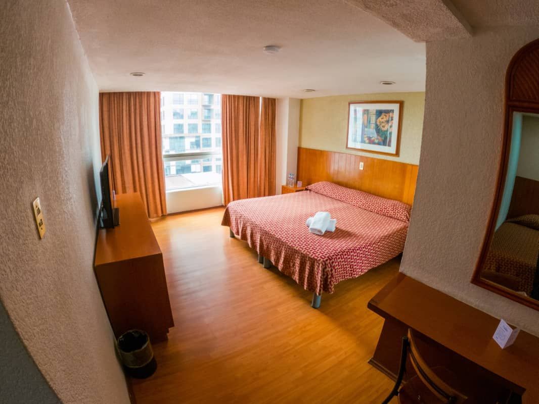 Una habitación de hotel con una cama grande y un escritorio.