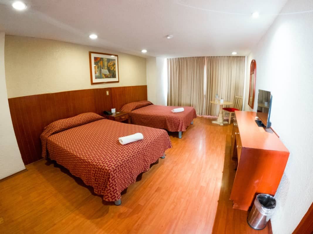 Una habitación de hotel con dos camas y televisión.