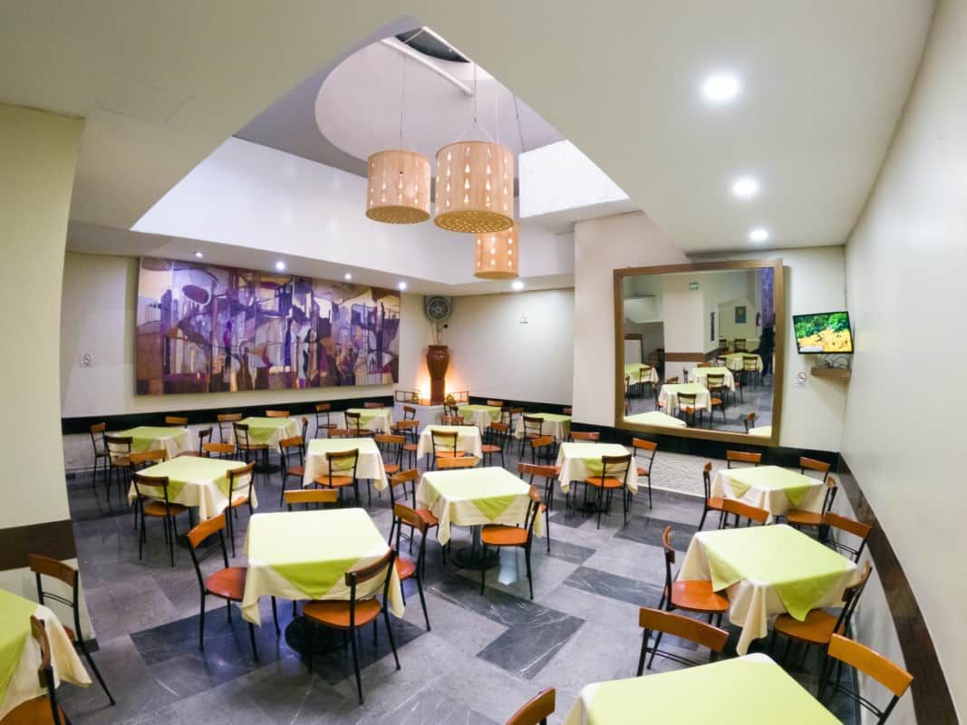 Un restaurante con mesas y sillas y un cuadro en la pared.