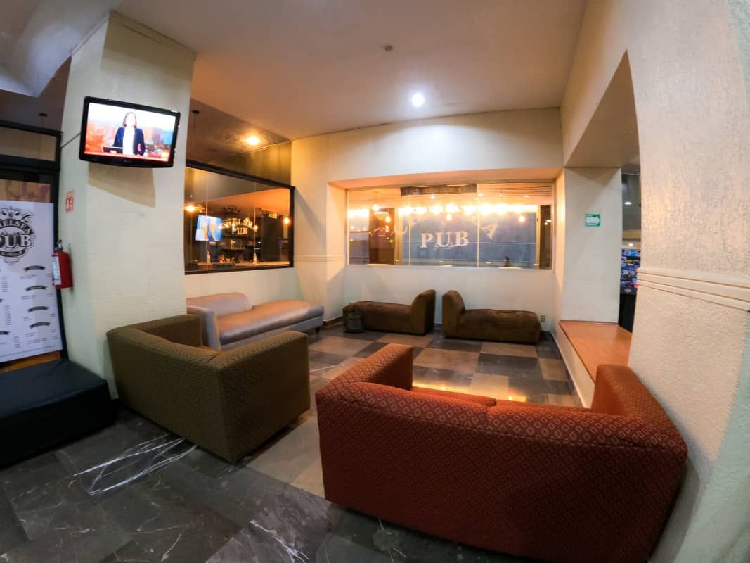 Una sala de estar con un sofá y un televisor en la pared.