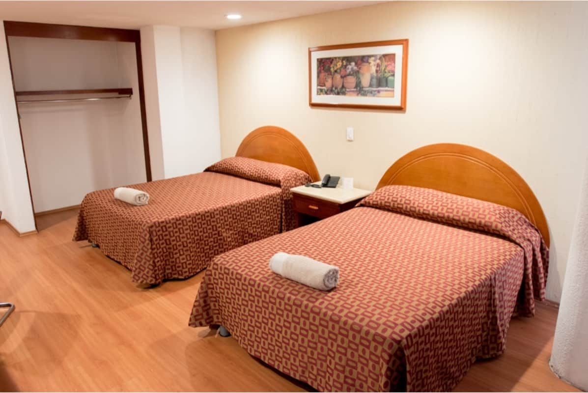 Una habitación de hotel con dos camas y un cuadro en la pared.