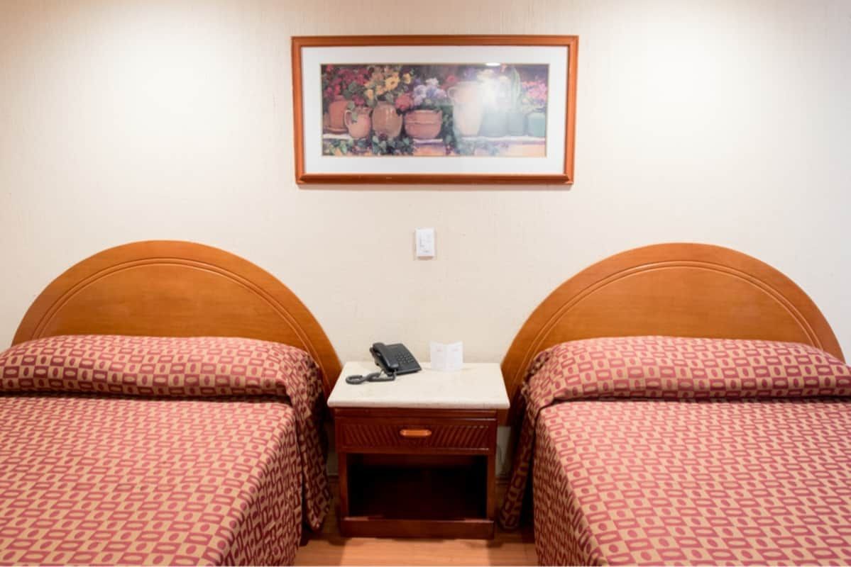 Una habitación de hotel con dos camas y un cuadro en la pared encima de ellas.