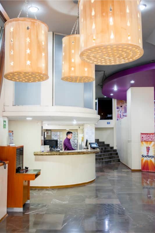 Un hombre está de pie detrás de un mostrador en un vestíbulo.