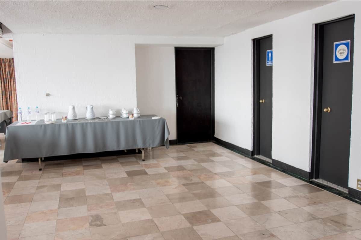 Un largo pasillo con una mesa y dos puertas.