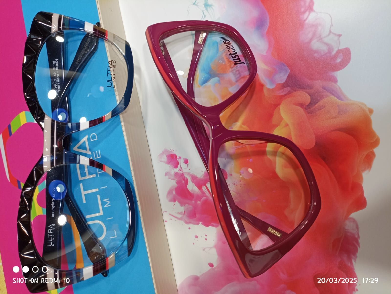 Due paia di occhiali sono appoggiati uno sopra l'altro su un tavolo.