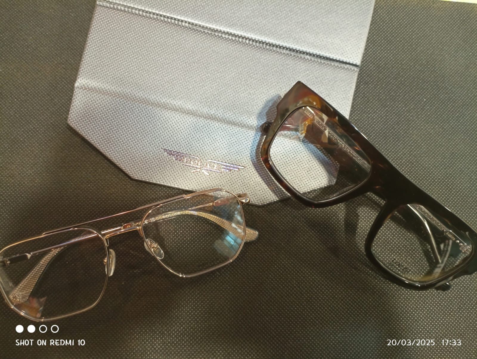 Due paia di occhiali sono appoggiati uno accanto all'altro su un tavolo.