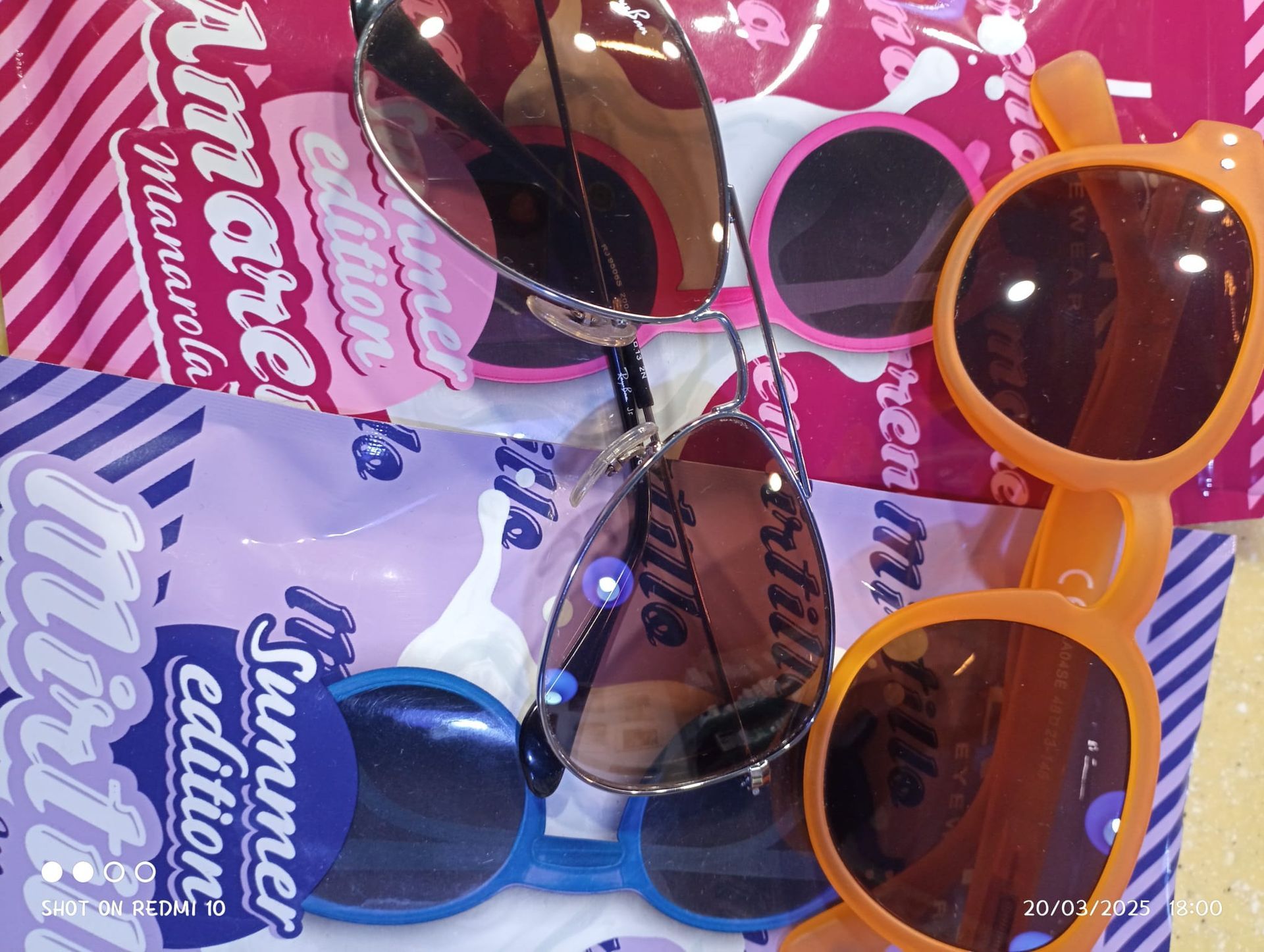 Un paio di occhiali da sole appoggiati su un panno a righe rosa e blu