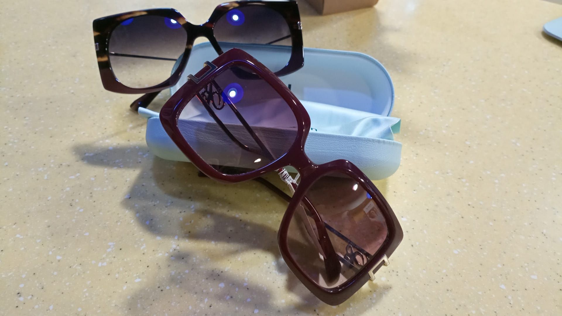 Un paio di occhiali da sole appoggiati su una custodia su un tavolo