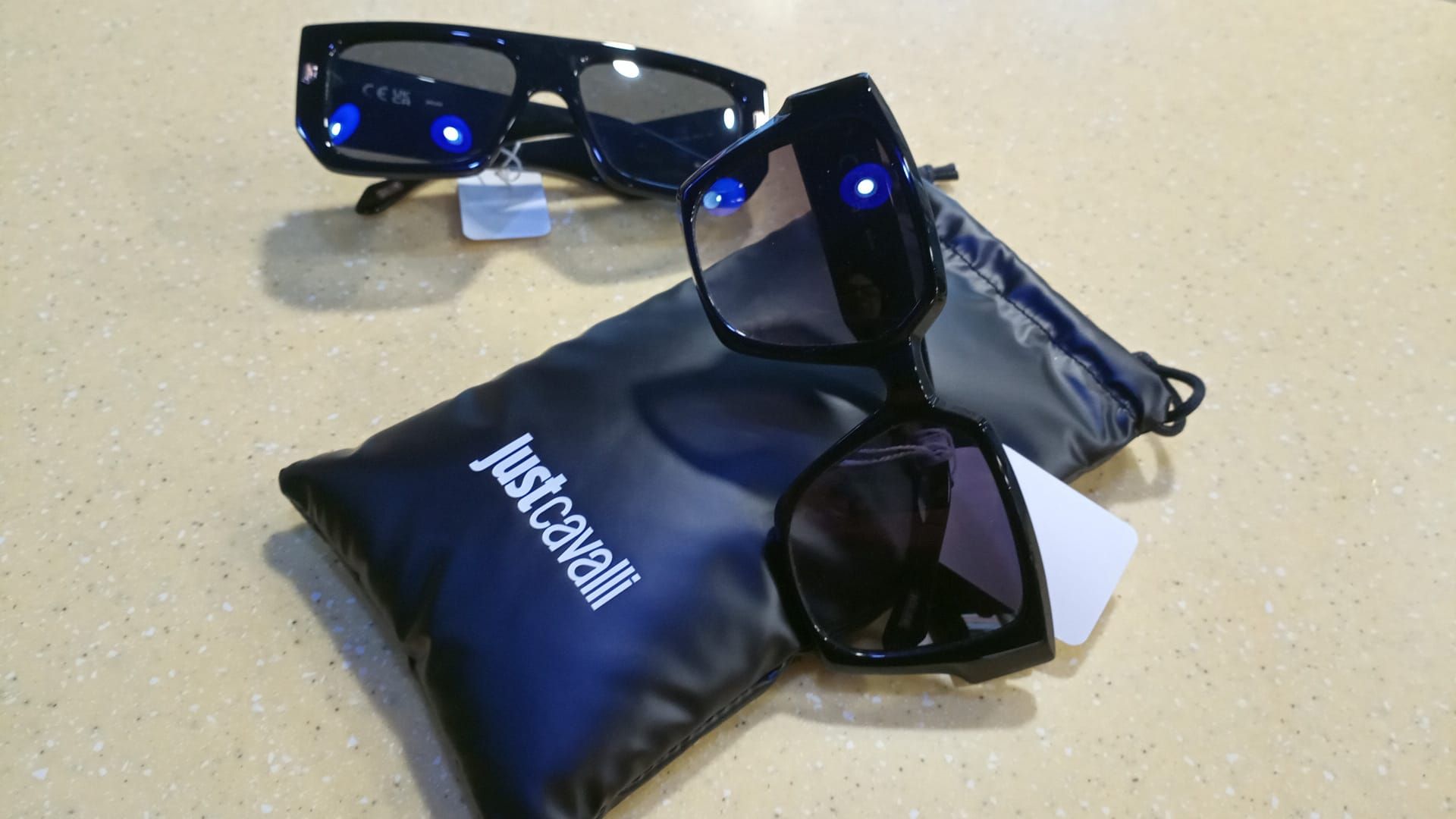 Un paio di occhiali da sole appoggiati sopra una borsa justcavalli