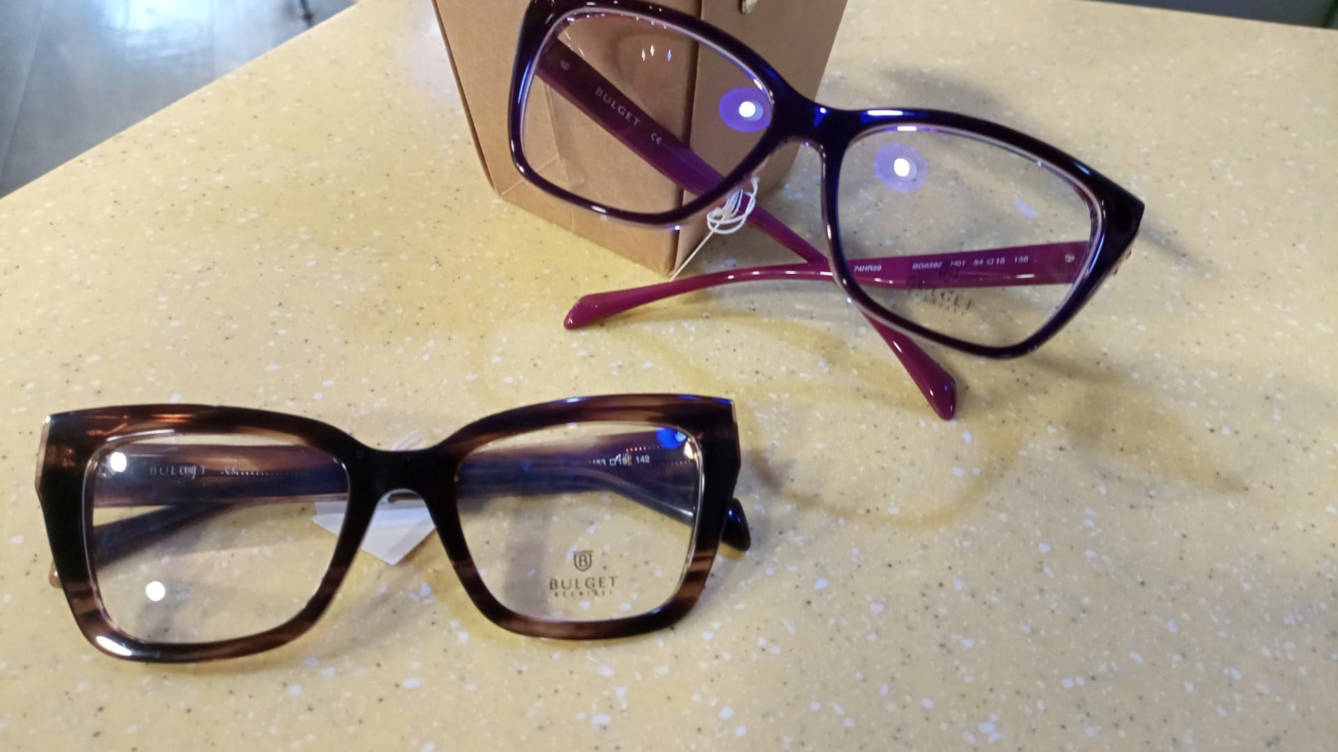 Due paia di occhiali sono appoggiati su un tavolo