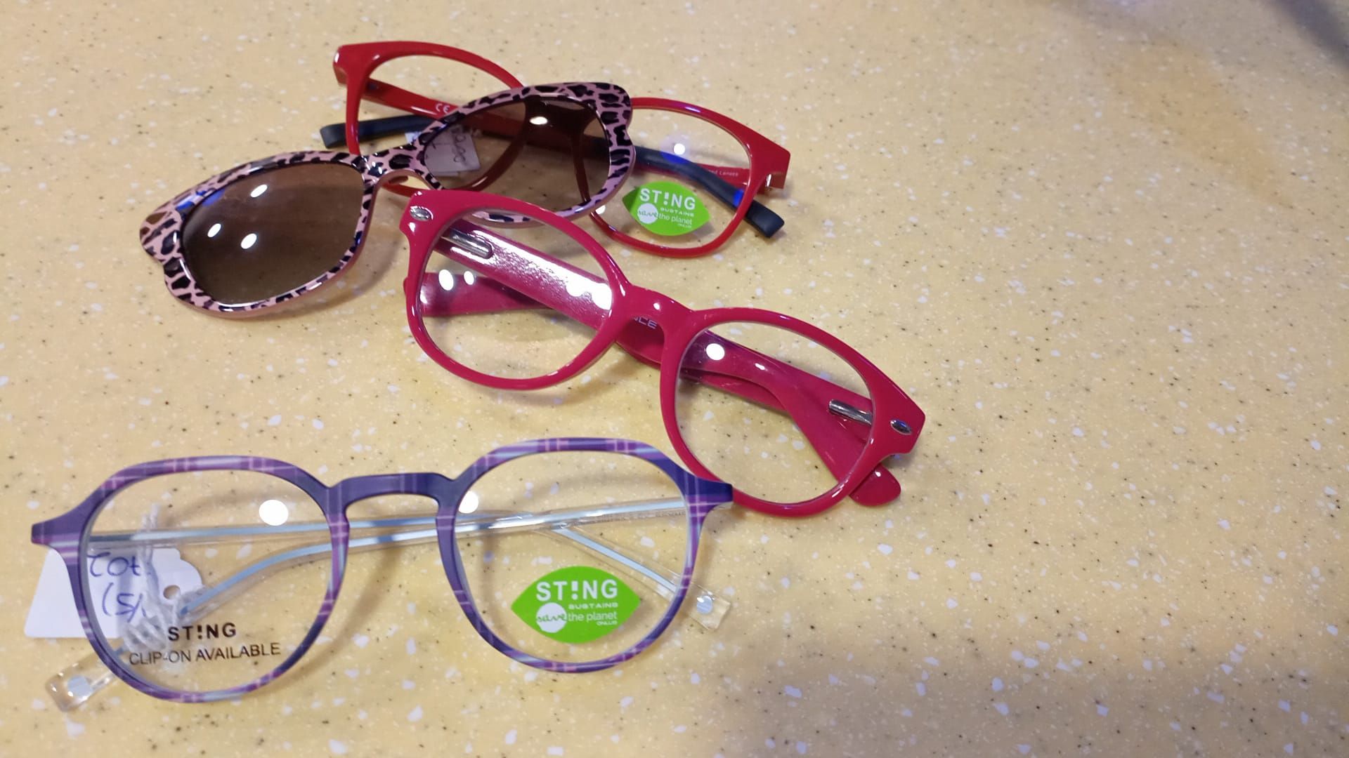 Tre paia di occhiali sono appoggiati su un tavolo