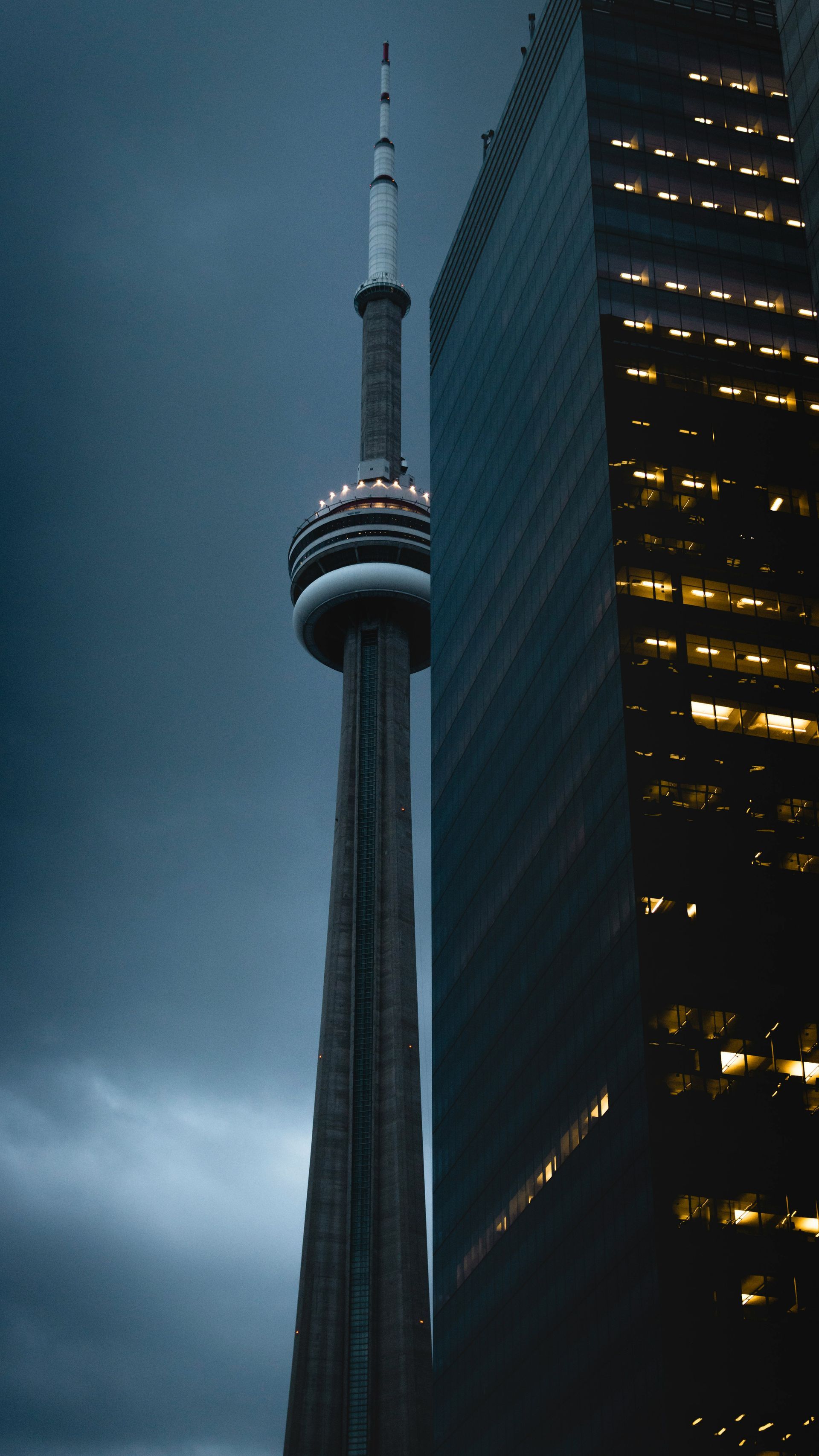 A very tall tower is between two tall buildings.