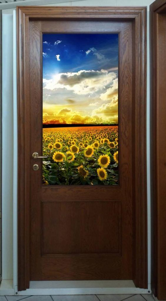 Una porta di legno con sopra raffigurato un campo di girasoli.