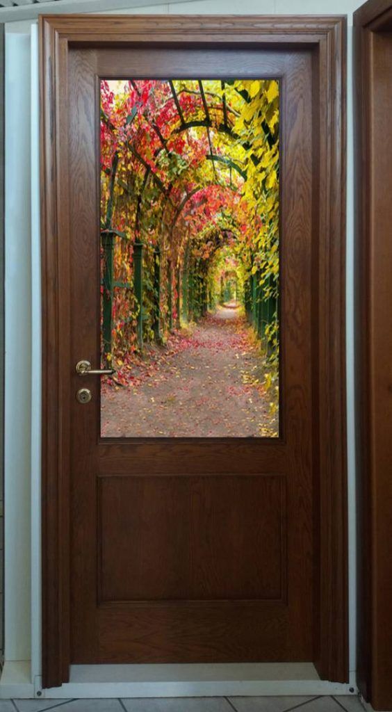 Una porta di legno con l'immagine di un sentiero nel bosco.