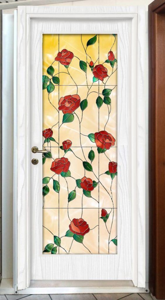 Una porta bianca con una vetrata decorata con rose rosse.