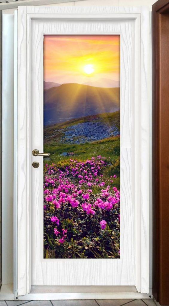 Una porta bianca con l'immagine di un tramonto e dei fiori.