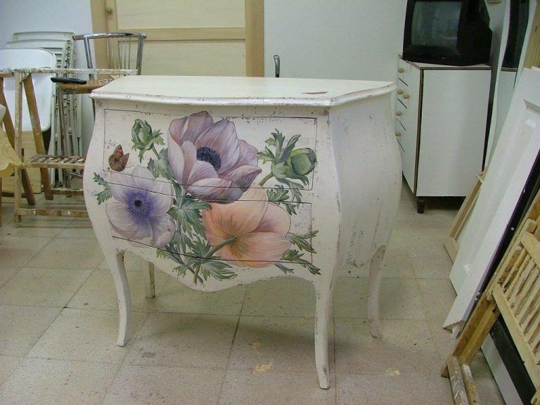 Una cassettiera bianca con dei fiori dipinti sopra