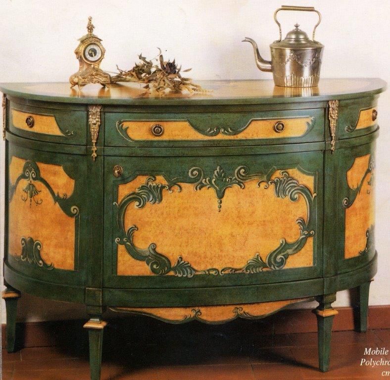 Una cassettiera verde e oro con un bollitore per il tè sopra