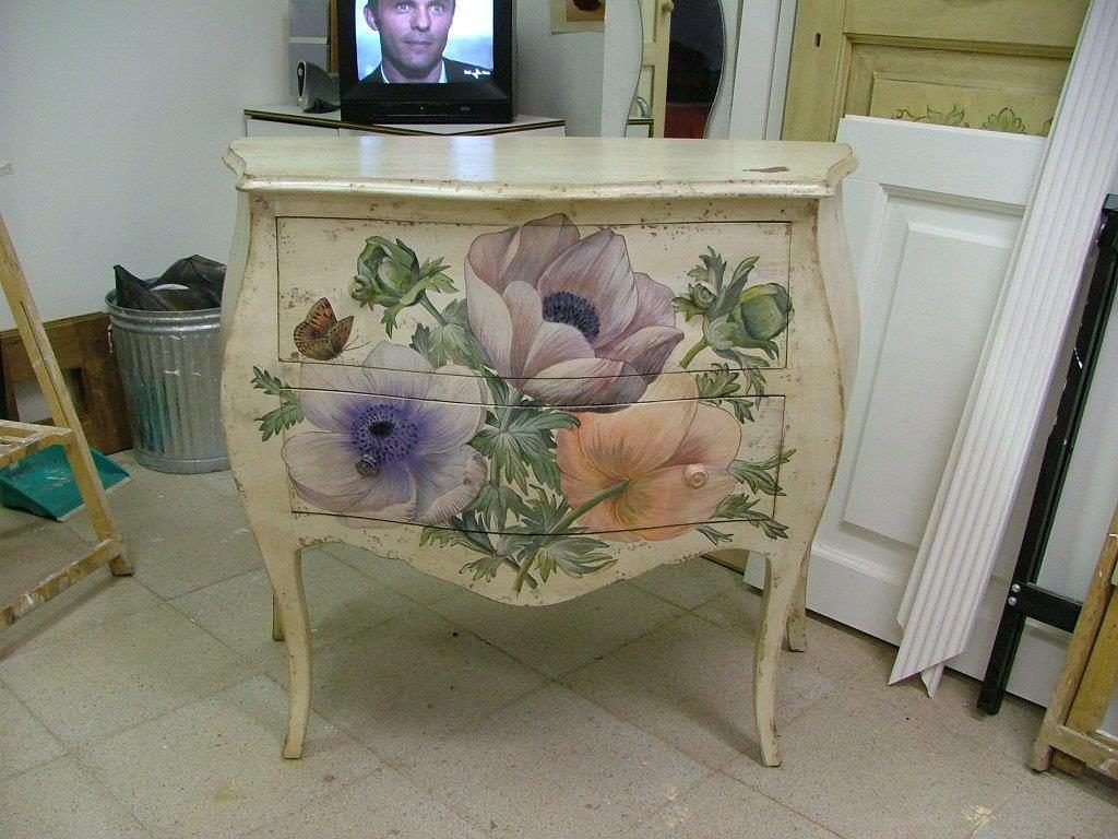 Una cassettiera bianca con dei fiori dipinti sopra