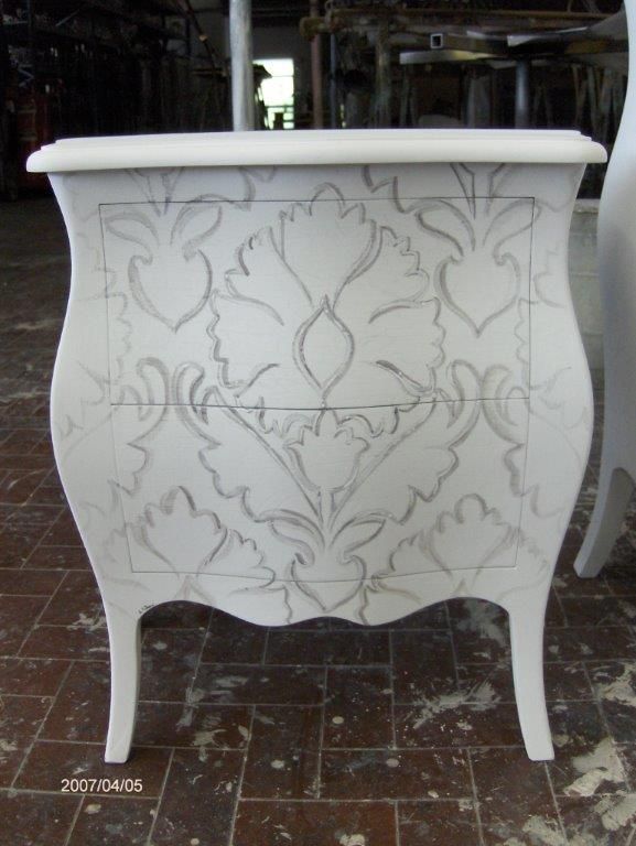 Una cassettiera bianca con un disegno floreale