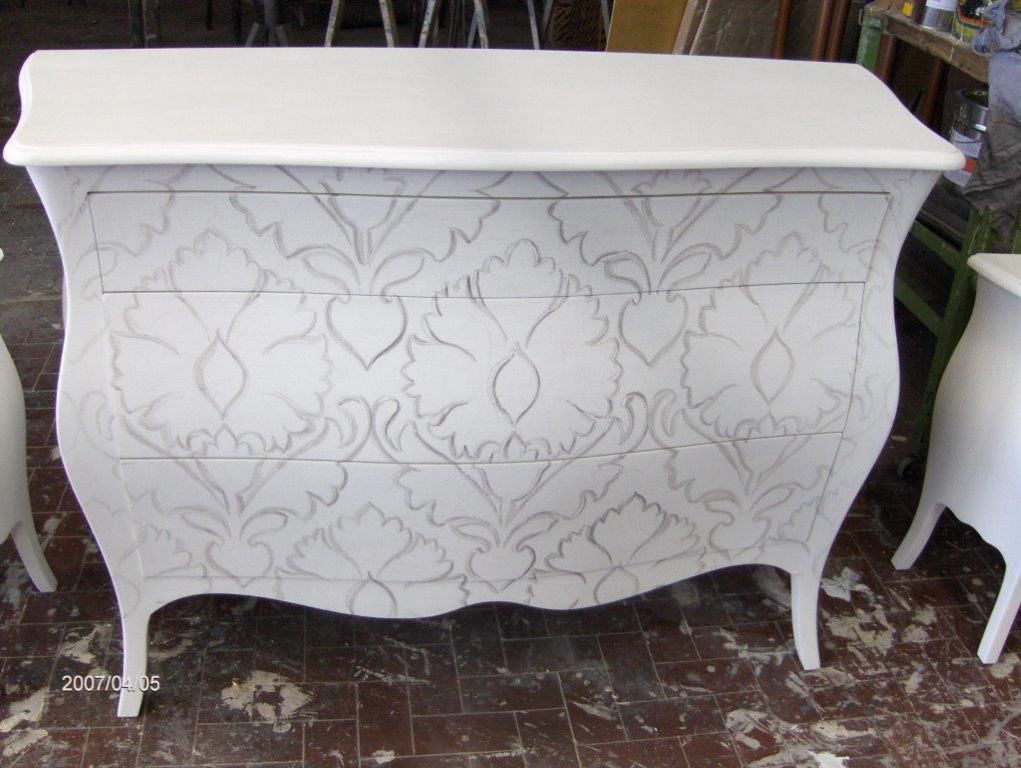 Una cassettiera bianca con un motivo sopra