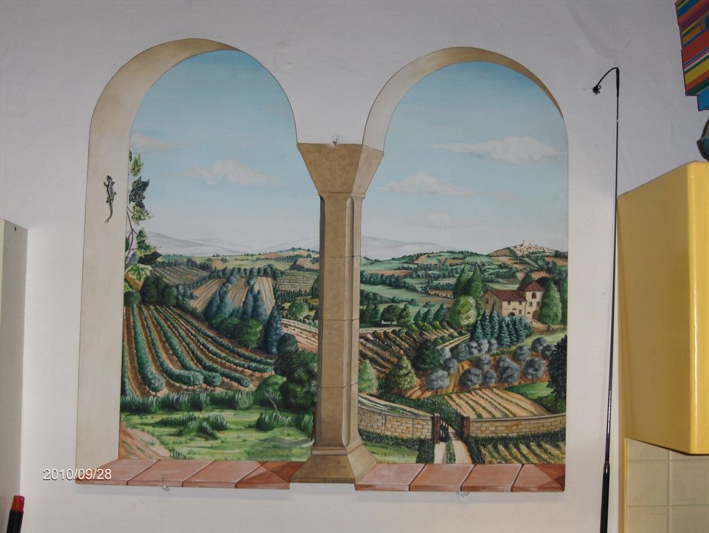 Un dipinto di un paesaggio con archi su un muro