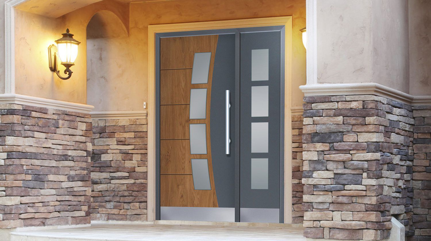 La porta d'ingresso di una casa con un muro di mattoni e una porta grigia.