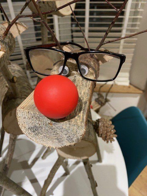 Wooden reindeer decoration wearing glasses and a red nose.