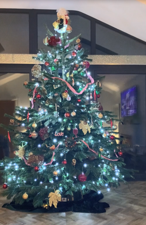 Festive Christmas tree decorated with lights and ornaments, indoors.