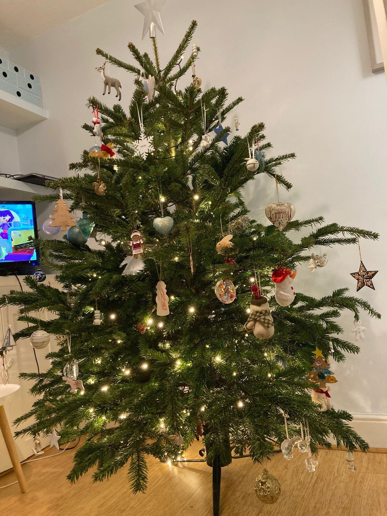 Christmas tree decorated with ornaments and lights indoors.