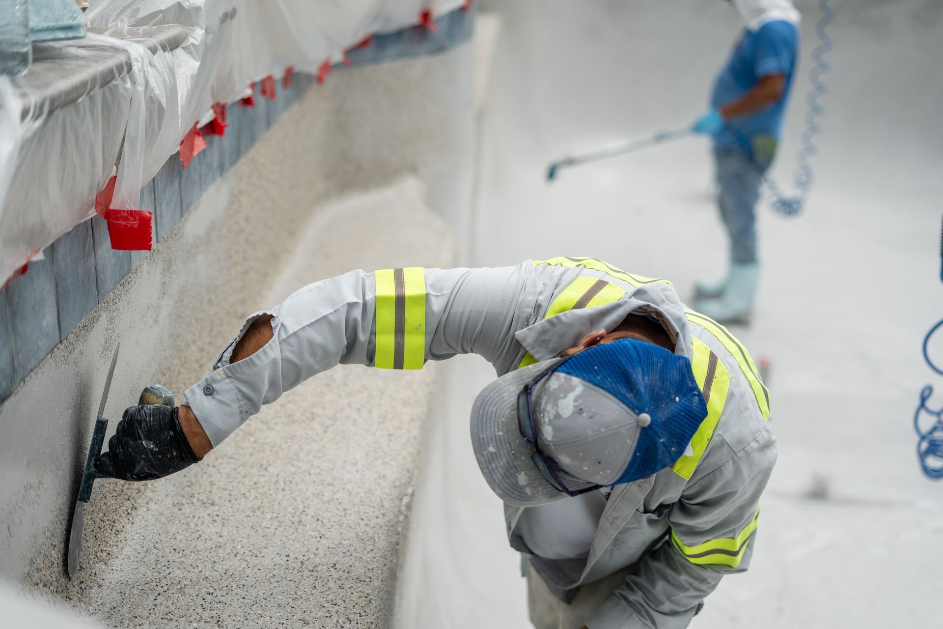 A man is applying a new finish to a swimming pool.
