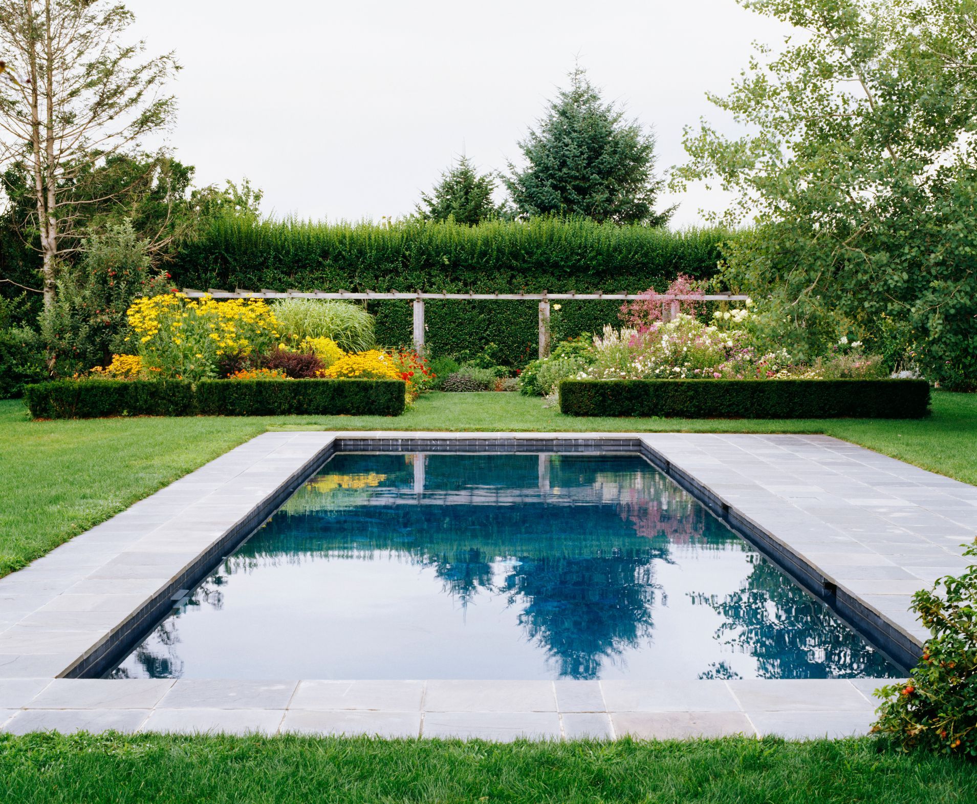 A swimming pool is seen in the lawn during the day.