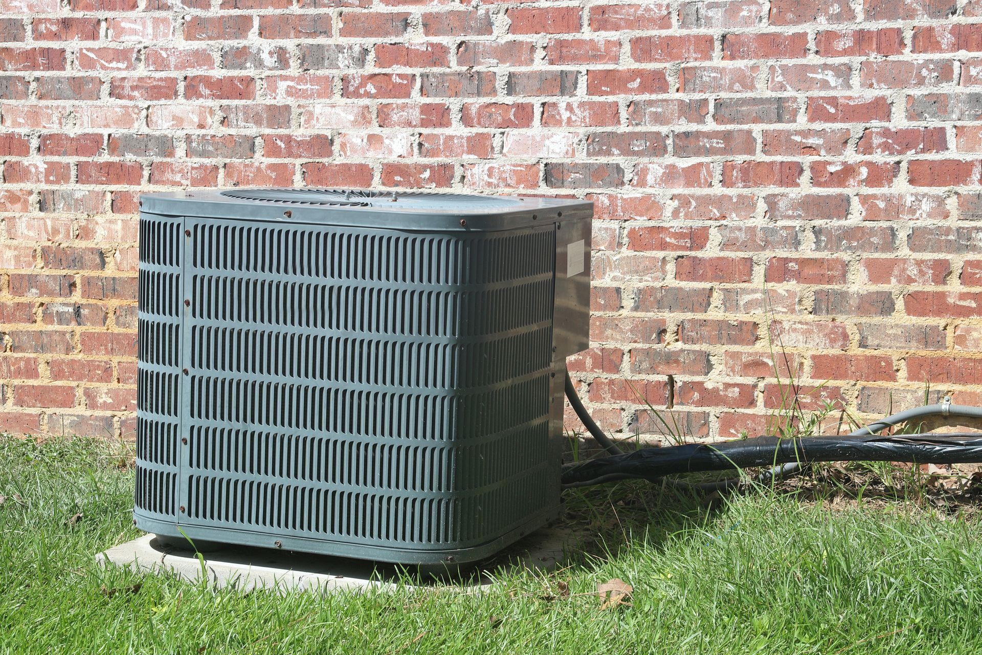 A close up of a broken air conditioner on a wall.