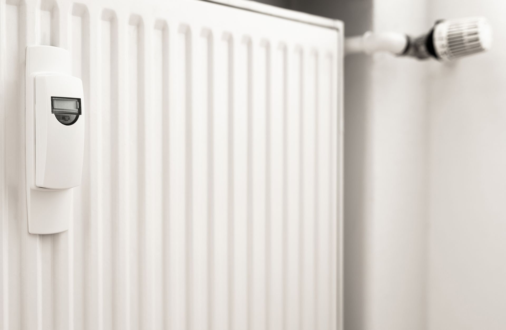 A white radiator with a thermostat attached to it.
