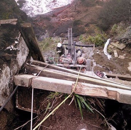A man is using a machine to dig a hole in the ground
