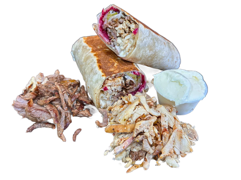 Shawarma wrap cut in half, with meat, sauce, and side of meat on brown surface.