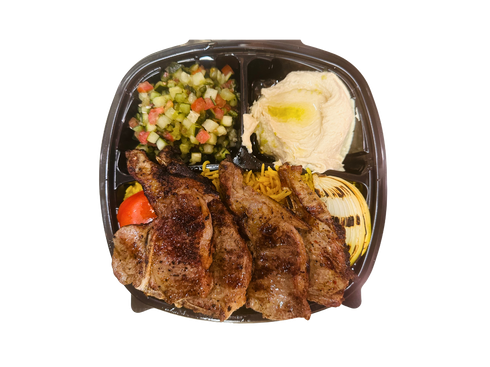 Grilled lamb chops with sides: salad, hummus, and rice in a black container.