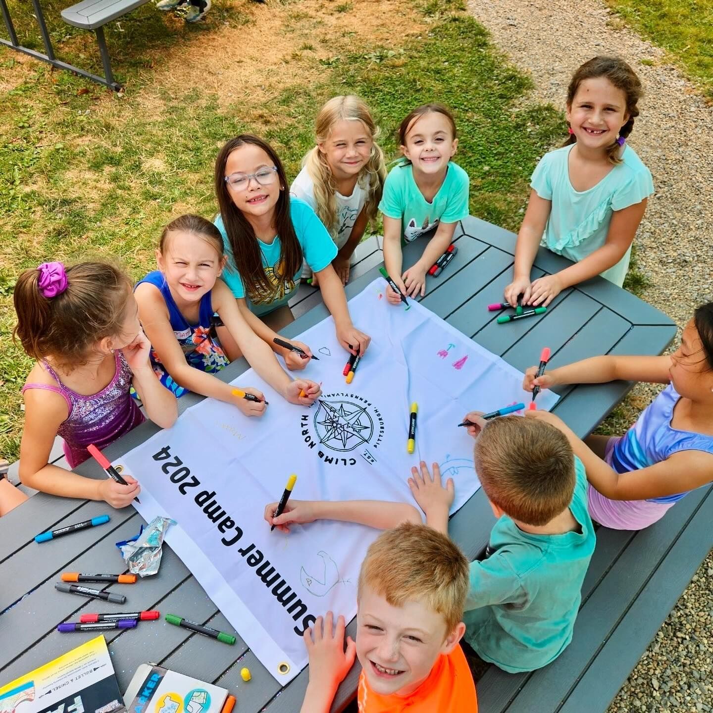 Children coloring a banner labeled 