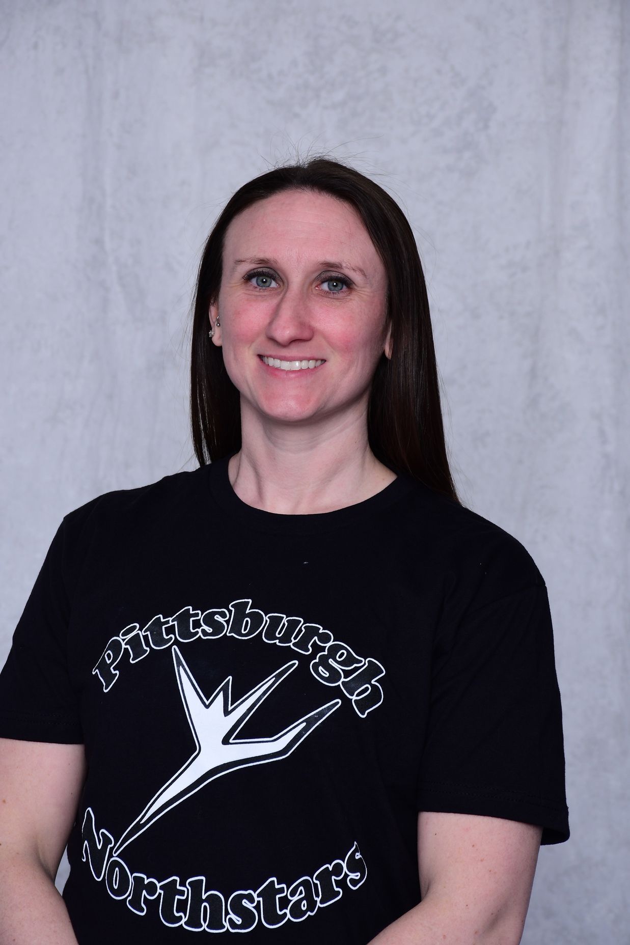 Woman wearing a black Pittsburgh Northstars t-shirt, smiling.