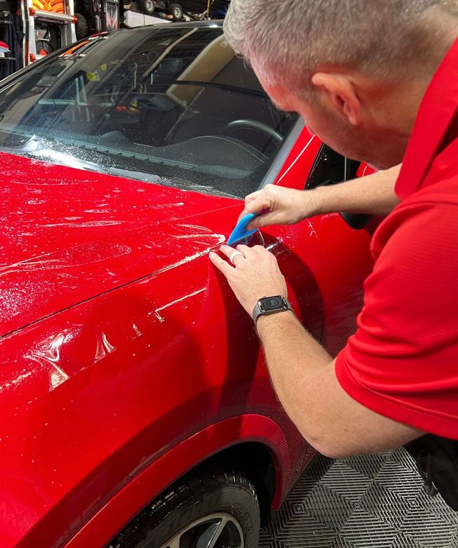 A person is washing a car wheel with foam