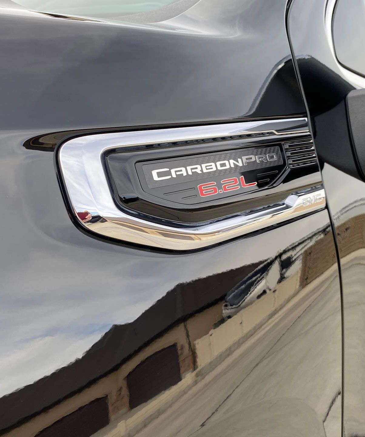A person is applying a clear film to the hood of a car.