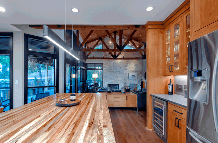 A kitchen with a wooden counter top , stainless steel appliances , and a refrigerator.